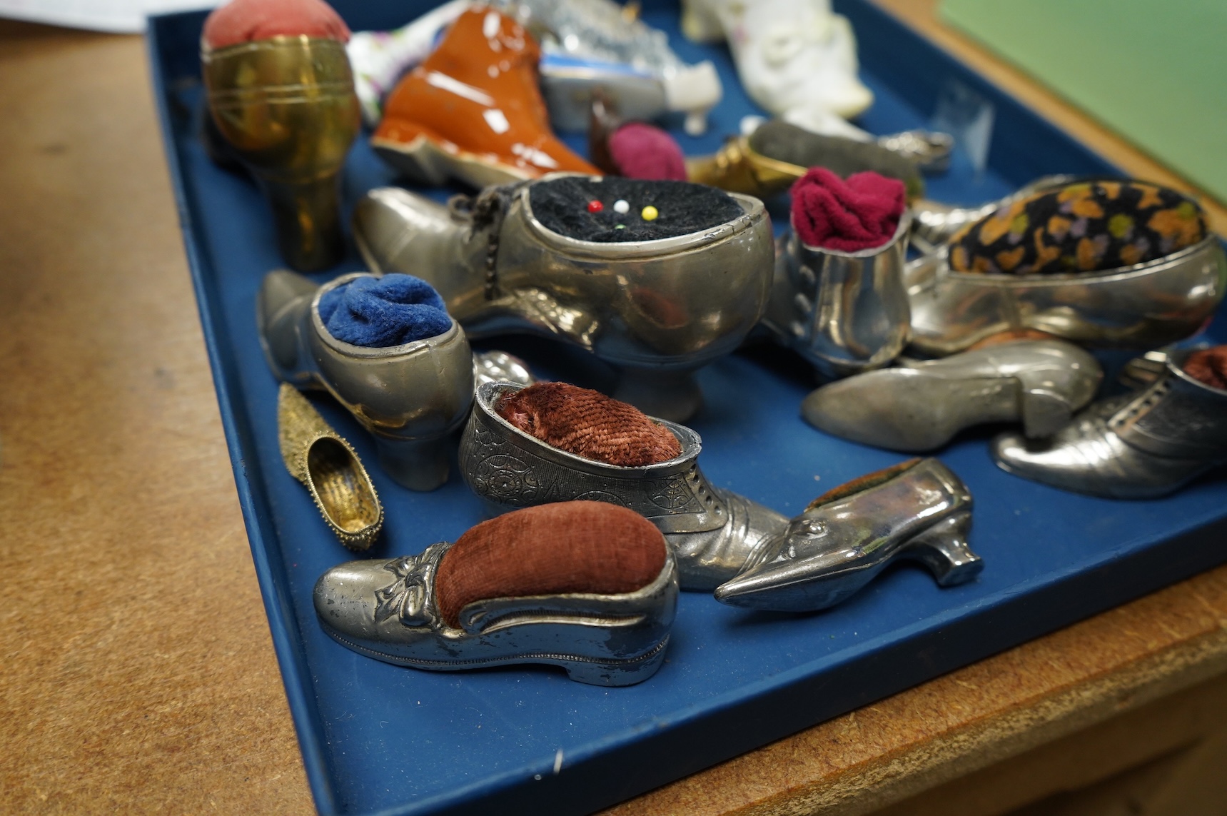 A collection of assorted miniature model shoes including pin cushions, one with modern silver mount